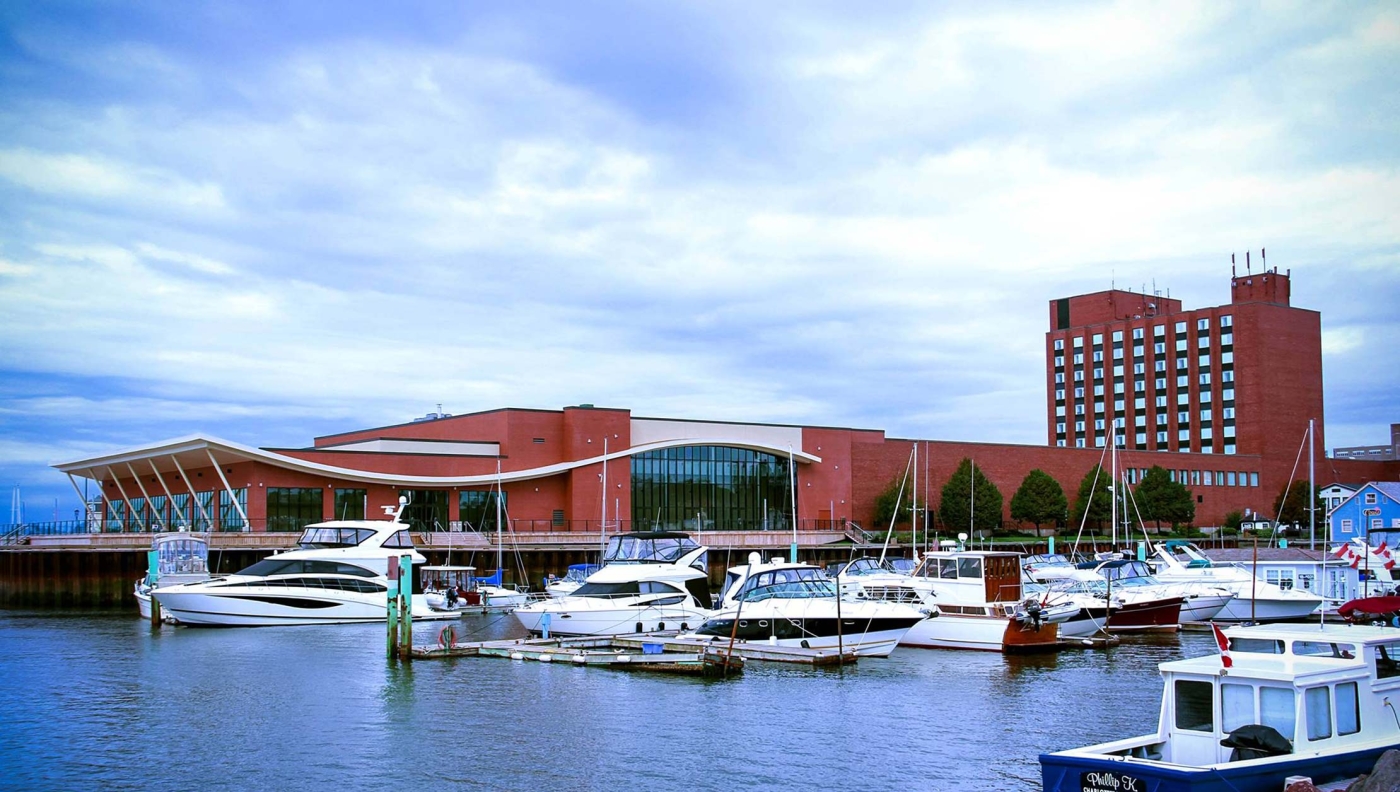 outside view of the large brick exterior of the Delta Hotel, with boats and water in for front